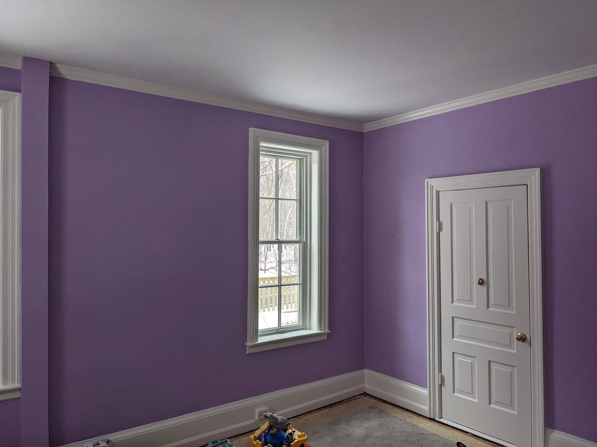 Bedroom walls finished against white trim and crown