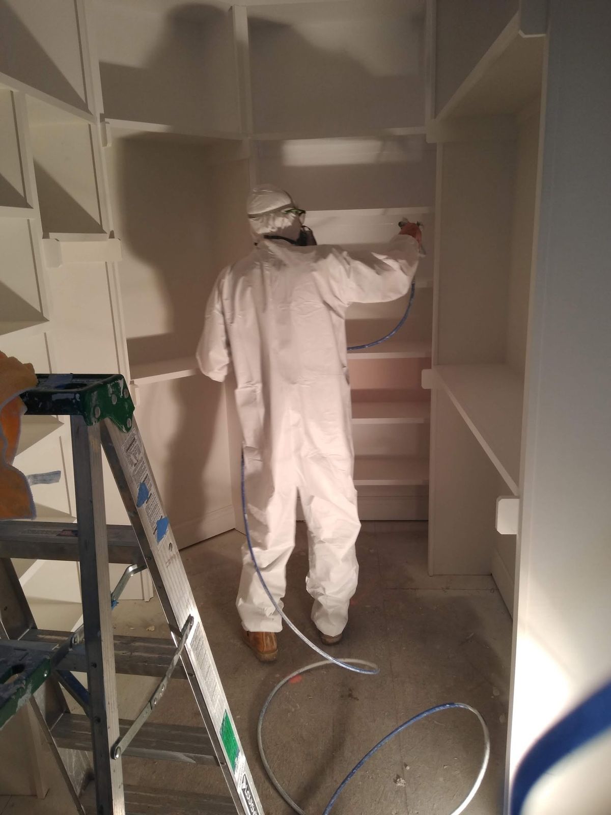 Spraying built-in shelving in full PPE